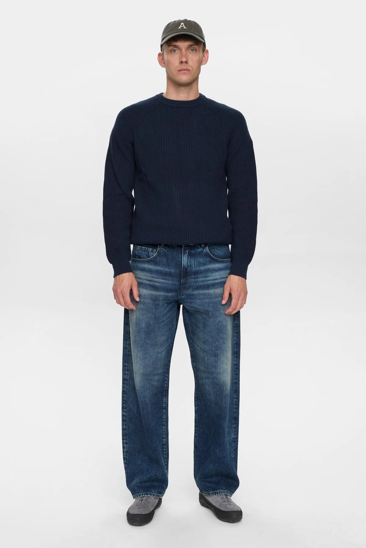 Dettaglio frontale ravvicinato del petto del maglione Anerkjendt AKSUNE Patent Knit Navy Blue indossato dal modello: zoom sulla texture a costine verticali fitte tono su tono e sul collo rotondo ribbed