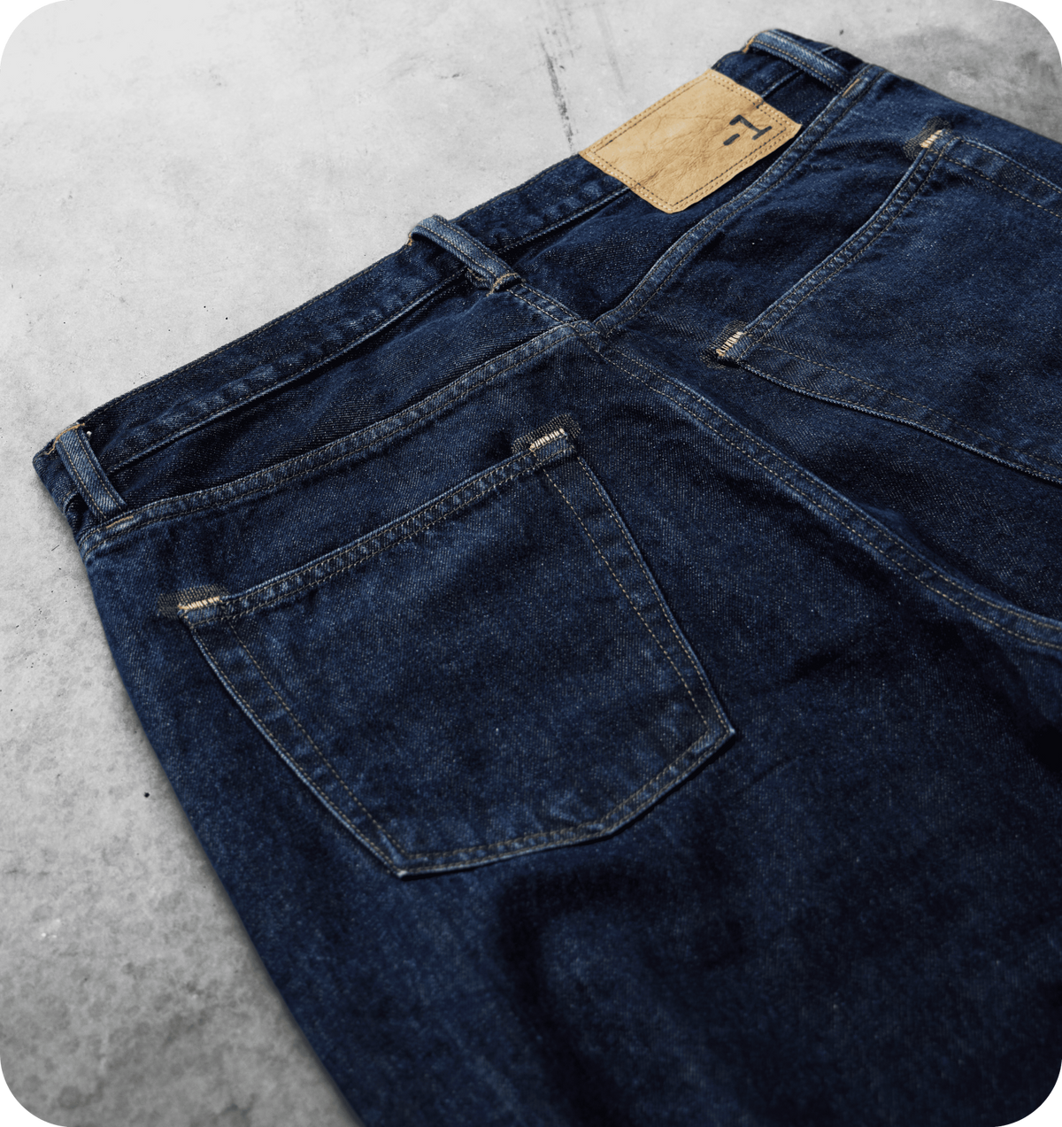 Dettaglio delle tasche posteriori e della patch con logo -1 sul denim blu scuro