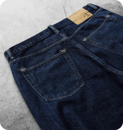 Dettaglio delle tasche posteriori e della patch con logo -1 sul denim blu scuro