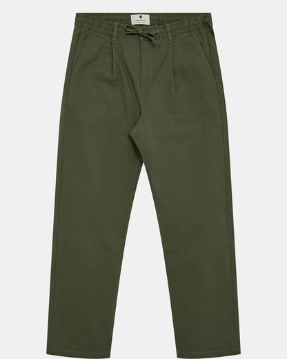 Vista frontale flat lay dei pantaloni Anerkjendt AKJAN Cotton Pleat Ela Pants in Khaki Sand su sfondo grigio chiaro: pantaloni uomo cotone beige sabbia vita elasticizzata coulisse con laccetto chiaro doppia pinces frontale tasche a filetto gamba tapered e patch Anerkjendt