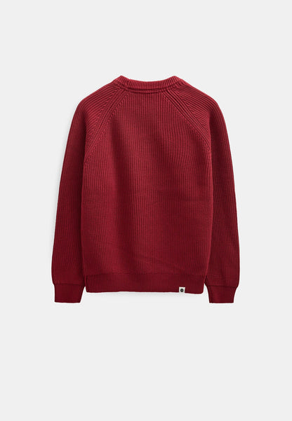 Dettaglio ravvicinato del collo rotondo ribbed e della spalla raglan del maglione Anerkjendt AKSUNE Patent Knit in rosso bordeaux: primo piano del tessuto a costine verticali fitte con etichetta interna bianca Anerkjendt visibile all interno del colletto