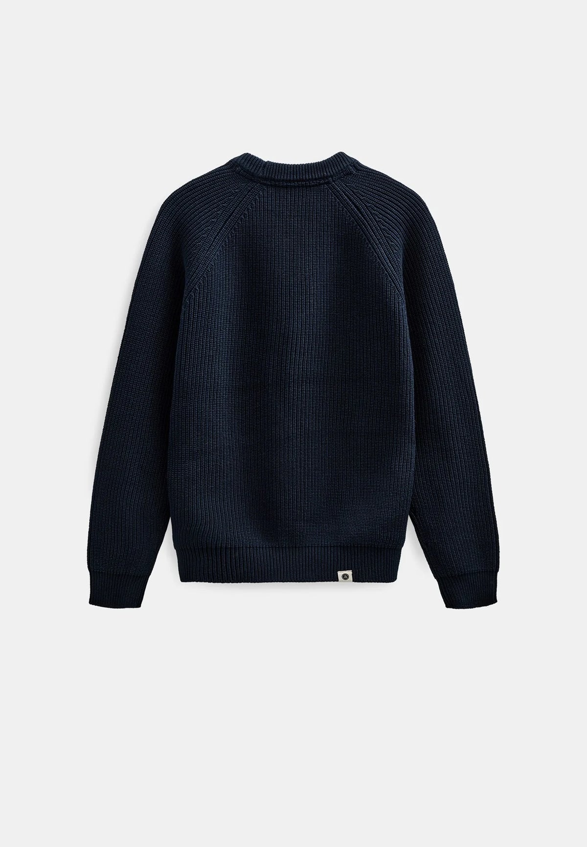 Modello maschile con cappellino verde oliva Anerkjendt indossa il maglione AKSUNE Patent Knit Navy Blue con jeans baggy lavaggio medio e sneaker grigie: vista frontale completa testa-piedi su sfondo bianco con maglione a costine blu navy e collo rotondo