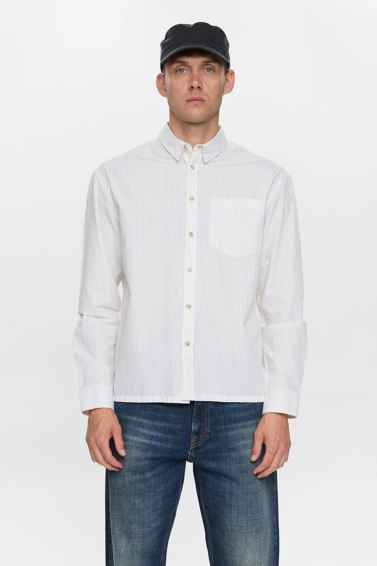 Vista posteriore intera del modello che indossa la Anerkjendt AKOTTO Poplin Stripe LS Shirt Bright White con jeans wide-leg lavaggio medio e scarpe scure: retro della camicia a righe con yoke e piega centrale su sfondo bianco
