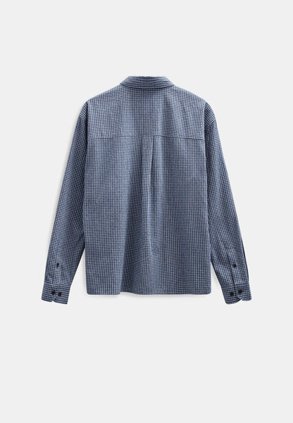Modello maschile con cappellino nero indossa la Anerkjendt AKOTTO Small Check LS Shirt Estate Blue con pantaloni chino beige e scarpe chunky nere: vista frontale intera testa-piedi su sfondo bianco con camicia a micro quadri blu navy fit boxy