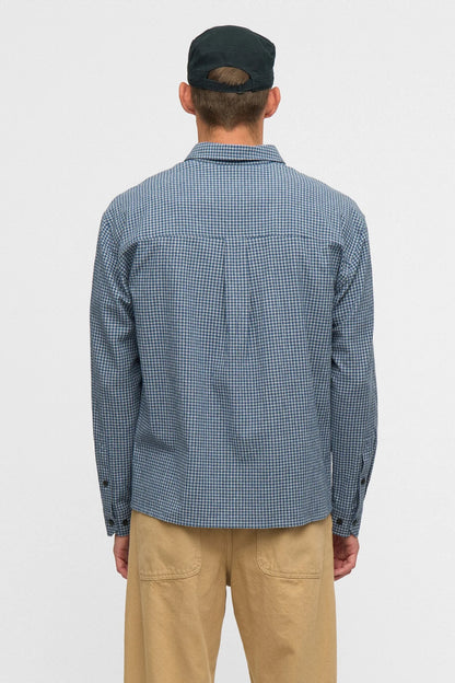 Vista posteriore flat lay della Anerkjendt AKOTTO Small Check LS Shirt Estate Blue: retro della camicia uomo a micro quadri blu navy e bianco con yoke posteriore piega centrale e polsini a doppio bottone scuro su sfondo grigio chiaro